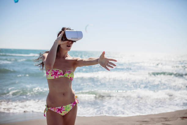 istock Woman looking through VR device on the beach. Summer concept 653424144