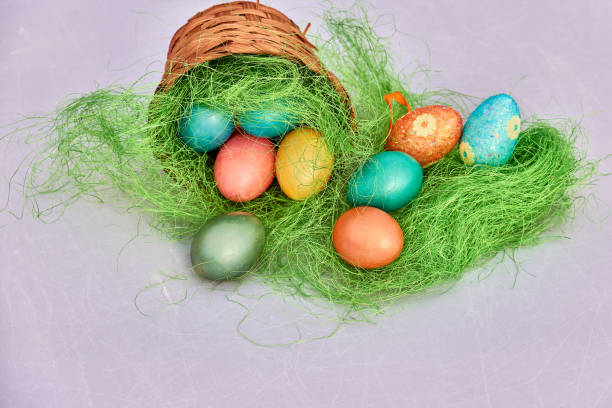 istock Easter basket filled with colorful eggs on a white background 653428386