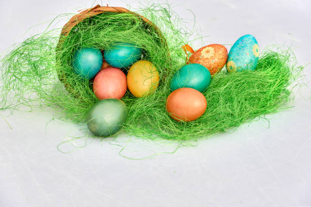 istock Easter basket filled with colorful eggs on a white background 653429352
