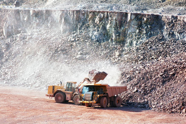istock Dumper trucking getting loaded by earth mover with rocks. quarry 653429576
