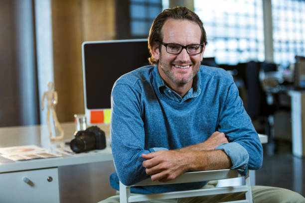 istock Businessman sitting on chair against computer desk 653429756