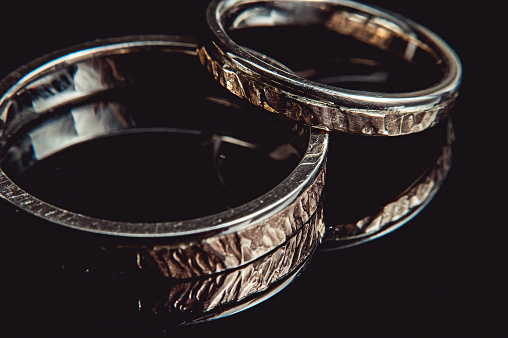 Hammered weddin rings on black background. macro. sparkle
