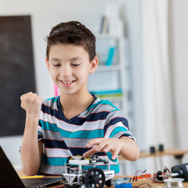istock Excited schoolboy finishes robot in science class 653433066