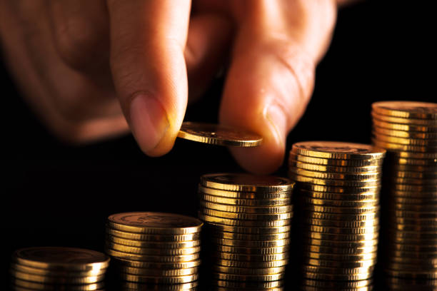 Hand putting money coins stack in finance and banking concept. stock photo