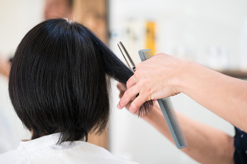 A woman getting her hair cut and styled at a hair salon