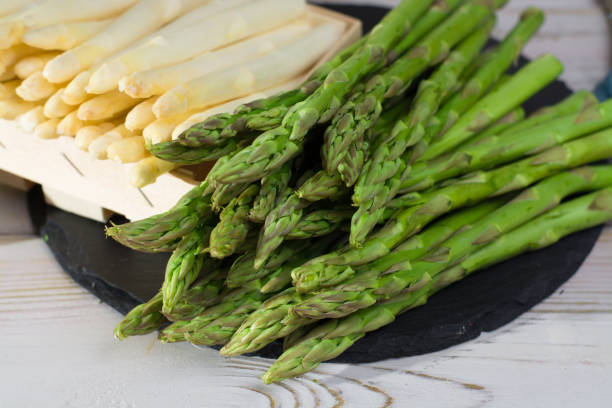 istock Spring season - fresh white and green asparagus on black stone plate 653439790