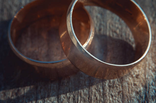 istock scratched two wide gold wedding rings on stone surface 653447950
