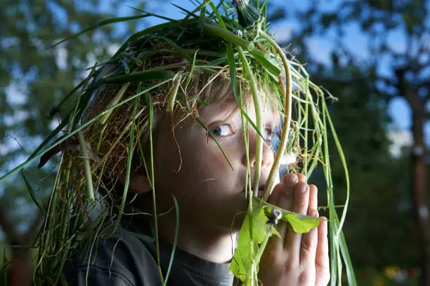 Photo of Portrait of a happy child. Wreath of grass on head