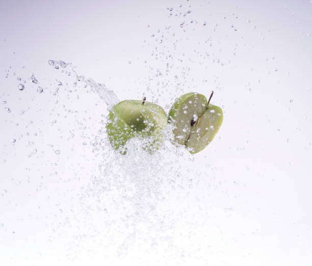 istock green apple and half apple in water splash on white background 653453266