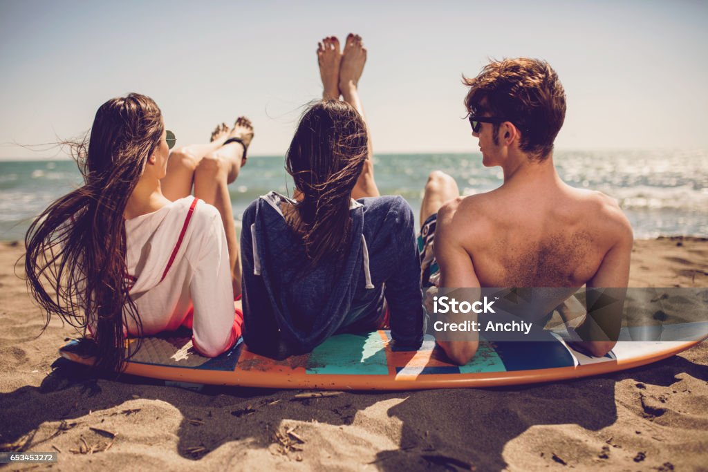 Grupo de amigos sonrientes con traje de baño y gafas de sol con tablas de surf en la playa. Verano concepto, amigos, amistad, diversión, gente joven que se divierte del verano - Foto de stock de Playa libre de derechos