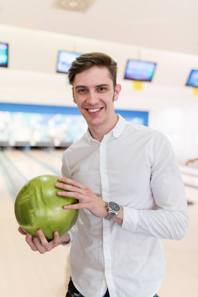 istock Charming young man posing with the bowling ball in his hand 653456160