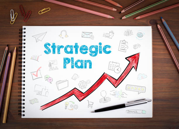 istock Strategic Plan. Notebooks, pen and colored pencils on a wooden table 653464642