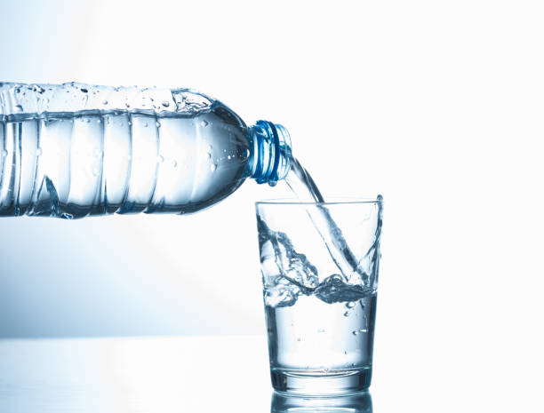 注ぐ水のボトルとグラスから - water bottle cold purified water ストックフォトと画像