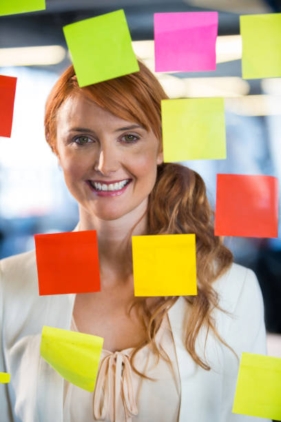istock Businesswoman seen through glass with adhesive notes 653468566