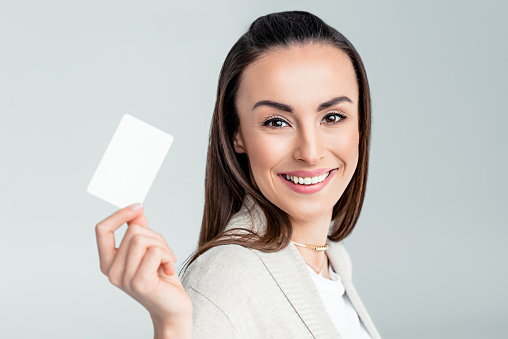 portrait of smiling woman holding credit card in hand and looking to camera
