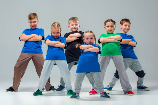 The kids dance school, ballet, hiphop, street, funky and modern dancers The kids dance school, ballet, hiphop, street, funky and modern dancers on gray studio background dance troupe stock pictures, royalty-free photos & images