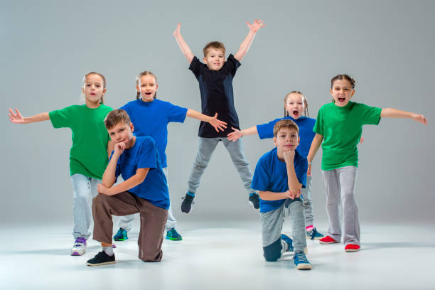 The kids dance school, ballet, hiphop, street, funky and modern dancers The kids dance school, ballet, hiphop, street, funky and modern dancers on gray studio background dance troupe stock pictures, royalty-free photos & images