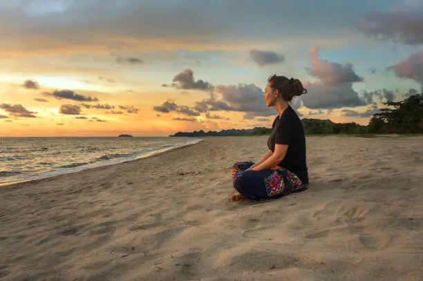 Photo of Woman relaxing on beach at sunset