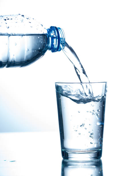 Pouring water from bottle into glass Pouring water from bottle into glass high quality and high resolution studio shoot pouring water from bottle stock pictures, royalty-free photos & images