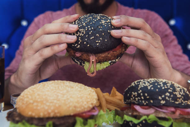 istock Man eating burgers 653487916