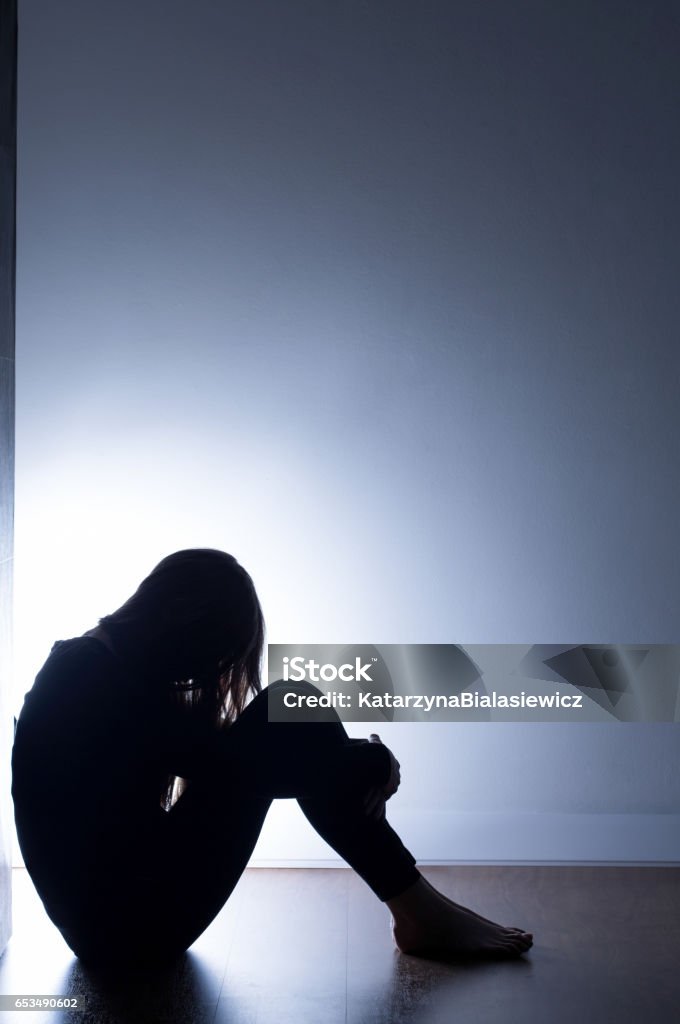 Black silhouette of teenage girl Black silhouette of teenage girl sitting on floor Depression - Sadness Stock Photo
