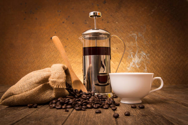 istock spilled coffee beans from sackcloth coffee cup coffee mug on old steel background 653494686