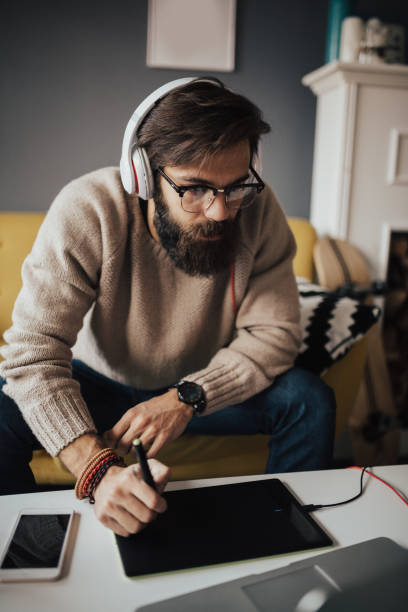 istock Web designer working from home with headphones on his head 653506072
