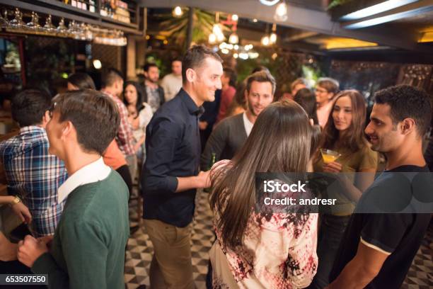 Friends Having Drinks At A Bar Stock Photo - Download Image Now - Cocktail Party, People, Standing