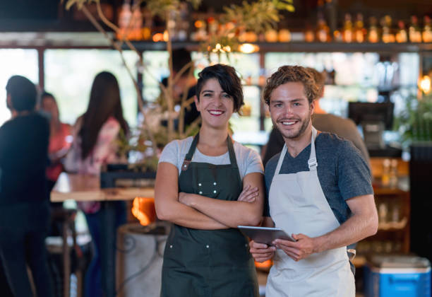 istock Business owner and waiter working at a bar using a tablet computer 653507604