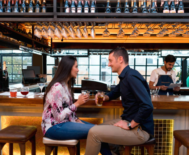 istock Happy couple having drinks at a bar 653507696