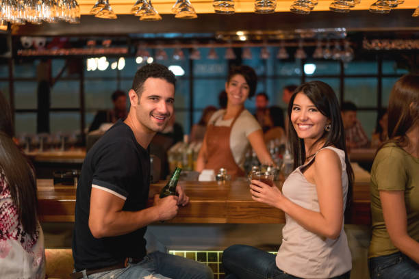 istock Happy couple having drinks at a bar 653509852