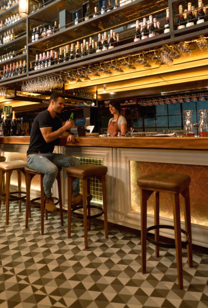 istock Man having drinks at a bar and talking to the bartender 653509858