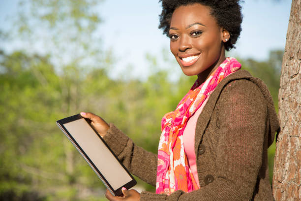 istock One African descent woman using digital tablet outdoors in park. 653516566