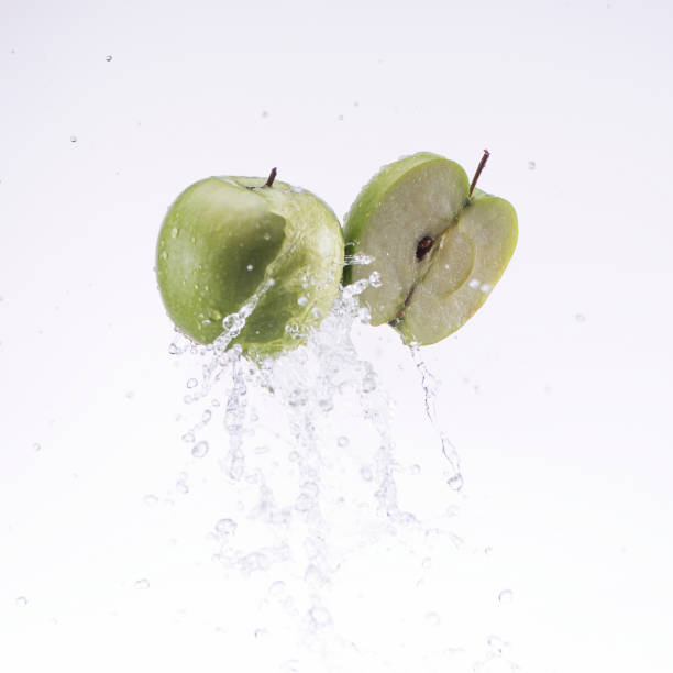 istock green apple and half apple in water splash on white background 653517062