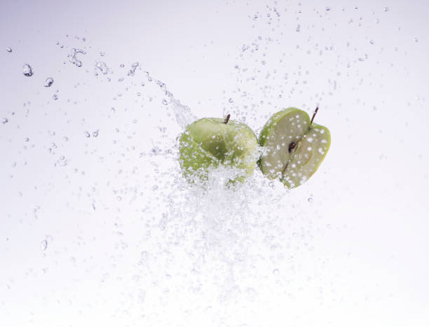 istock green apple and half apple in water splash on white background 653517066
