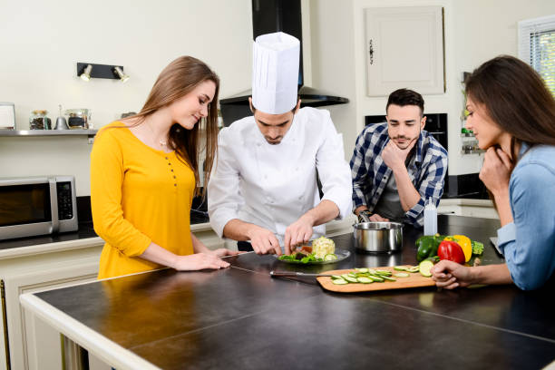 istock professional personal chef cook in customer's private kitchen house giving a cooking lesson to young people at home 653517108