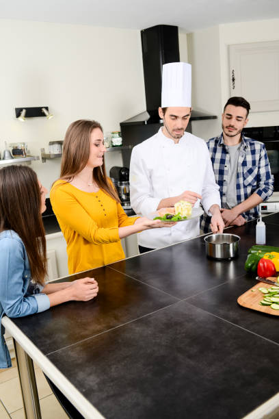 istock professional personal chef cook in customer's private kitchen house giving a cooking lesson to young people at home 653517112