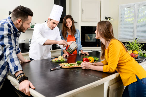 istock professional personal chef cook in customer's private kitchen house giving a cooking lesson to young people at home 653517132