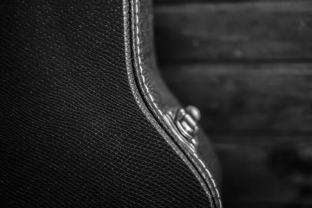 istock Black guitar case with wooden background 653517276