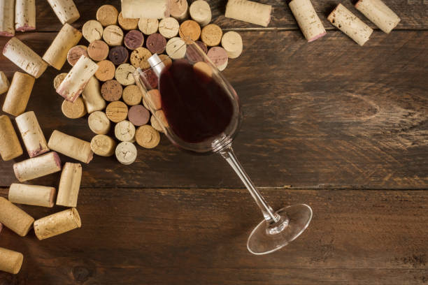 istock Glass of red wine and corks on dark background 653518012