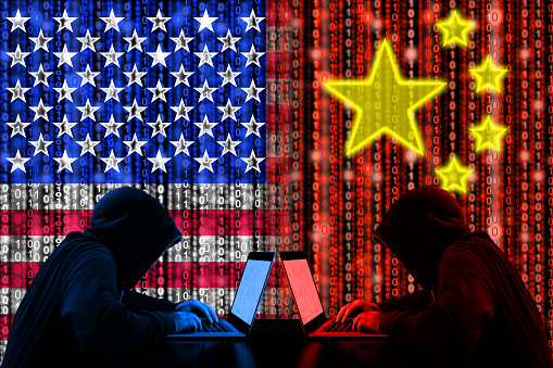 American hacker sitting opposite of a chinese hacker cyberwar concept in front of binary flags