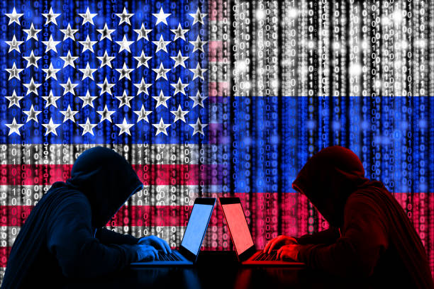 American hacker sitting opposite of a russian hacker cyberwar concept stock photo
