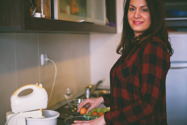 istock Cracking an egg to a bowl. Close-up of woman cracking egg for pastry 653521540