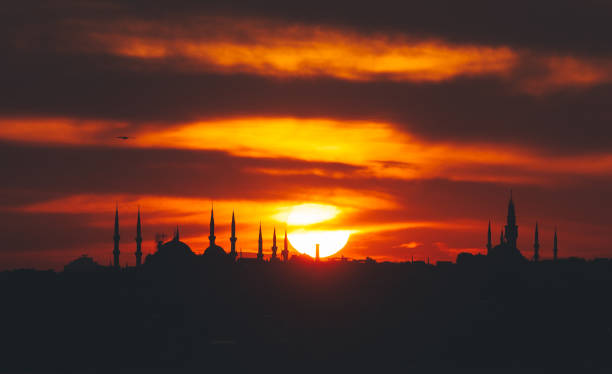 Silhouette of blue mosque in historical area of istanbul and bosphorus with dramatical cloudy sunset