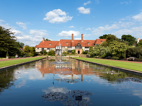 Wisley, England - June 23, 2015: Visitors at the canal and main building with the laboratory, a Grade II listed building. In front a scuplture by Henry Moore. Royal Horticultural Society Garden Wisley