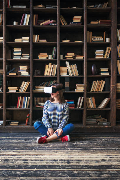 istock Young woman choosing VR Glasses over books 653532864