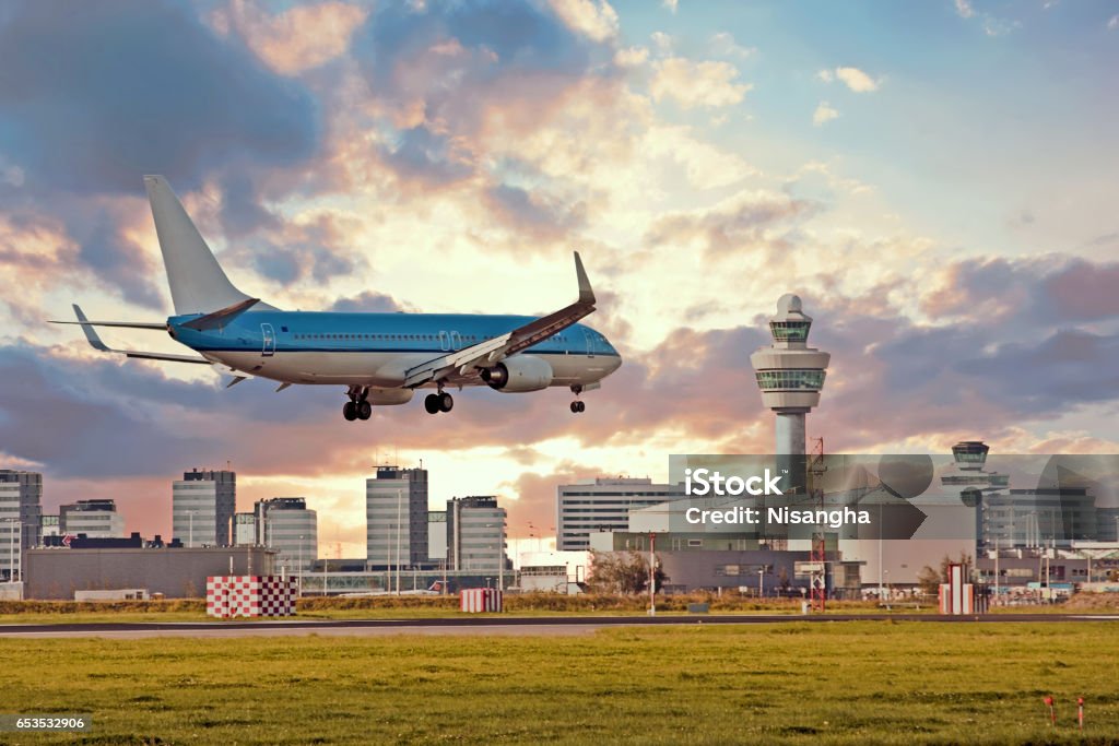 Airplane landing on Schiphol airport in Amsterdam in the Netherlands Airplane landing on Schiphol airport in Amsterdam in the Netherlands at sunset Amsterdam Schiphol Airport Stock Photo