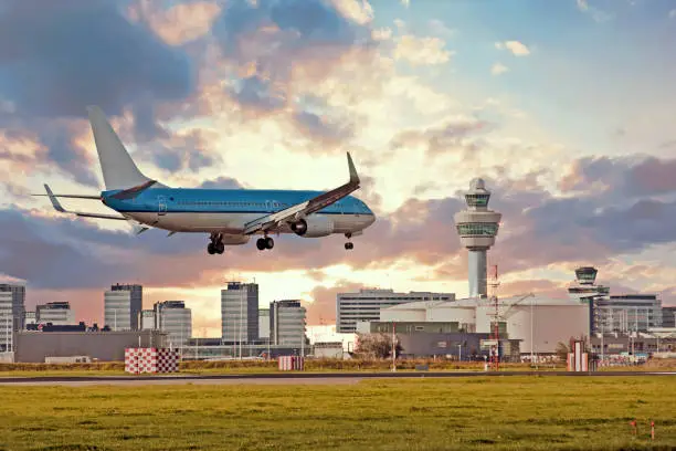 Airplane landing on Schiphol airport in Amsterdam in the Netherlands at sunset