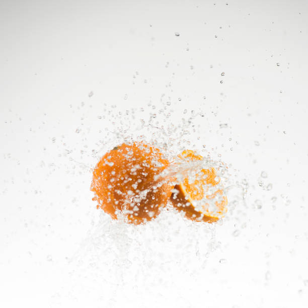 istock orange and half orange in water splash on white background 653536534