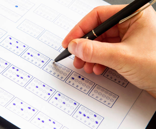 istock Filling exam questionnaire,hand with pen marking right answers at school or university 653540048